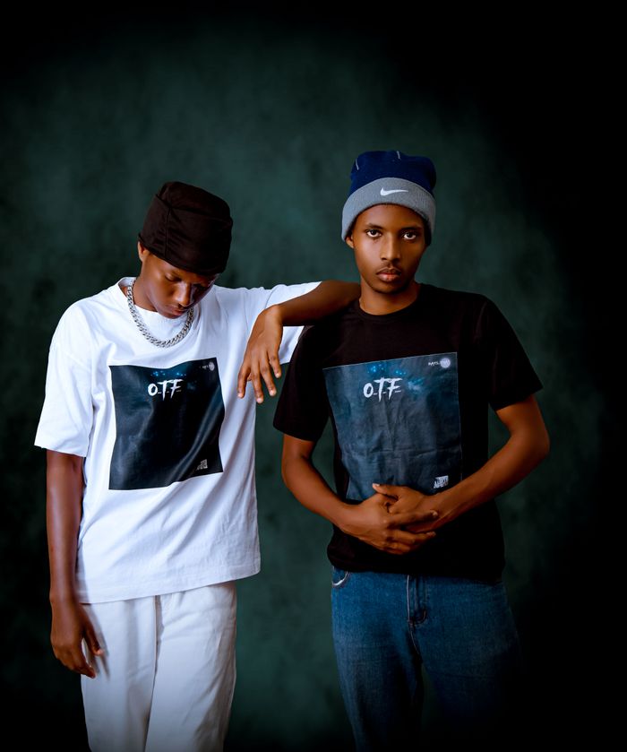 Two young men in trendy t-shirts posing for a fashion portrait in Kigali.